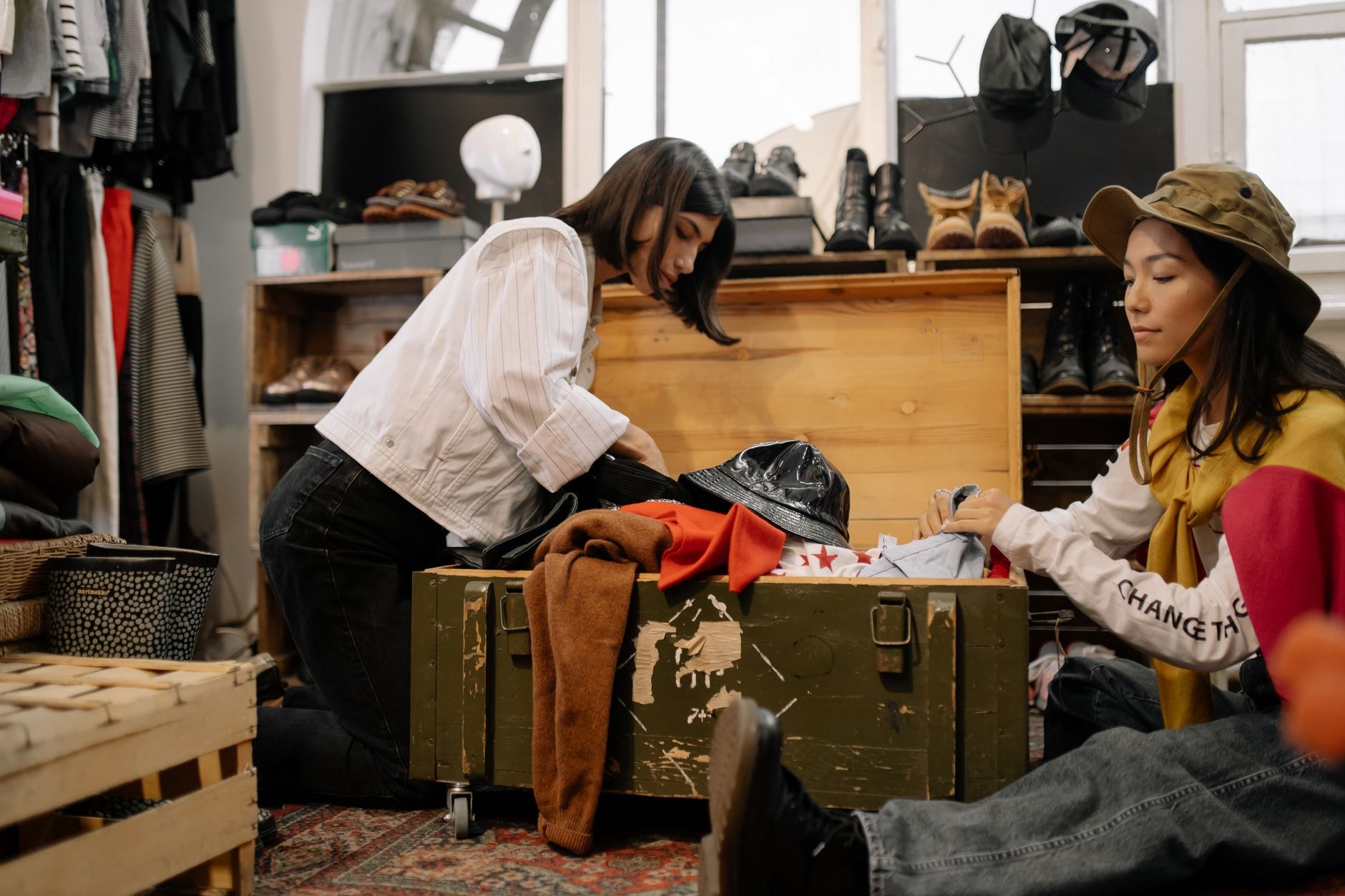 Două tinere alegând haine second-hand